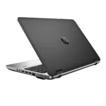 Open HP laptop viewed from the left-rear angle, showing the dark lid with HP logo and part of the keyboard and left-side ports